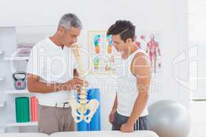 Doctor showing anatomical spine to his patient