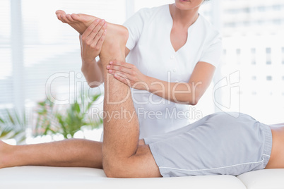 Physiotherapist doing leg massage to her patient Physiotherapist doing leg massage to her patient
