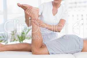 Physiotherapist doing leg massage to her patient