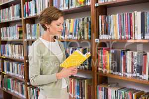 Teacher reading book at library