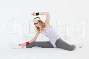 Geeky hipster stretching her legs on the floor