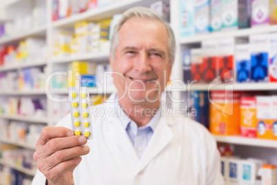 Senior pharmacist holding blister packs