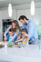 Happy family preparing vegetables together