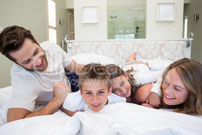 Happy family playing on the bed