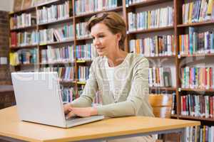 Focus teacher using laptop at library