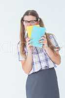 Geeky hipster hiding her face behind notepad