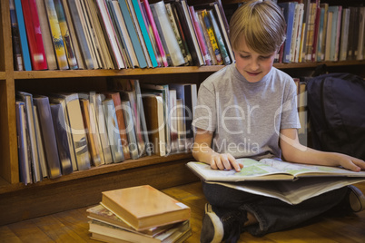 Little boy reading on library floor