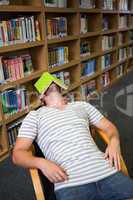 Student asleep in the library with book on his face