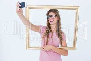 Pretty blonde taking a selfie of herself holding frame