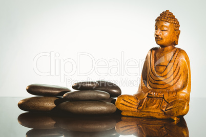 Wooden buddha statue with balancing pebbles