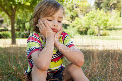 Sad little boy in the park