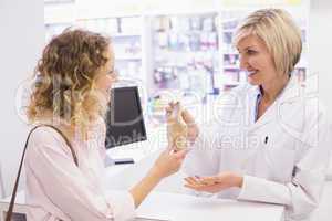 Pharmacist giving medicine to costumer