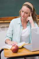 Teacher reading book at her desk