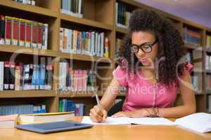 Student sitting in library writing