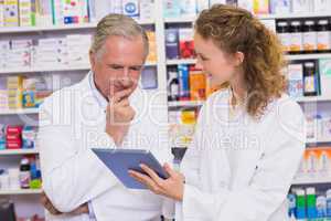 Team of pharmacist looking at tablet pc