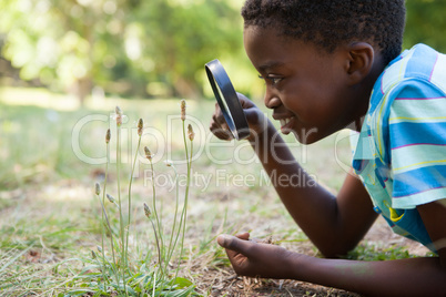 Cute little boy looking through magnifying glass