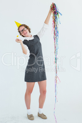 Happy geeky hipster holding confetti and horn