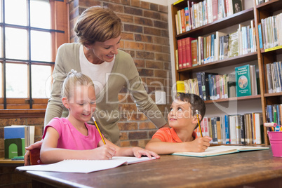 Teacher helping pupils in library