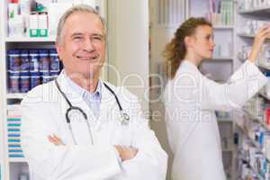 Pharmacist looking at camera with student behind him