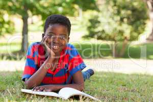 Little boy reading in the park