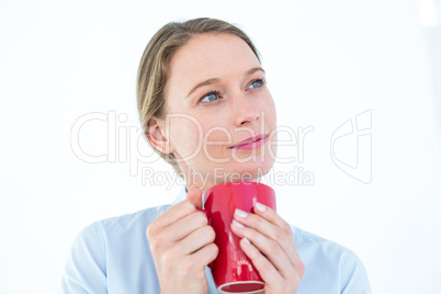 Businesswoman holding her mug and thinking Businesswoman holding her mug and thinking