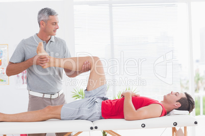 Physiotherapist doing leg massage to his patient