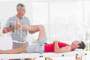 Physiotherapist doing leg massage to his patient