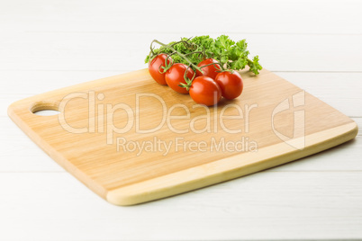 Cherry tomatoes and parsley on chopping board