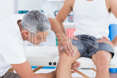 Doctor examining his patient knee