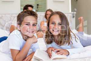 Happy family on the bed reading book