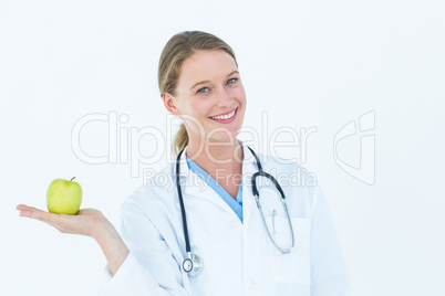 Smiling doctor offering an apple