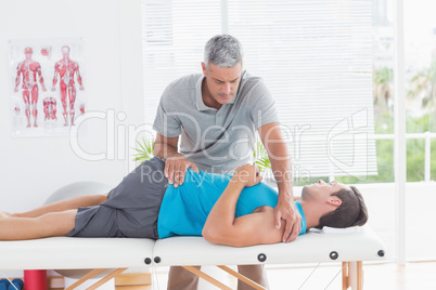 Doctor stretching a young man back