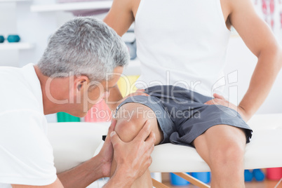 Doctor examining his patient knee