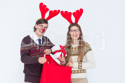 Happy geeky hipster couple holding present