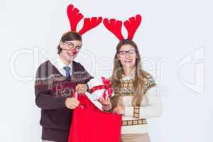 Happy geeky hipster couple holding present