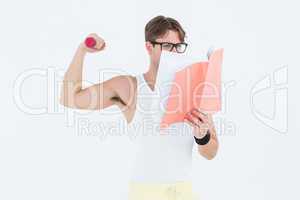Geeky hipster lifting dumbbells and reading notepad