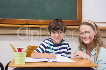 Teacher and pupil smiling at camera