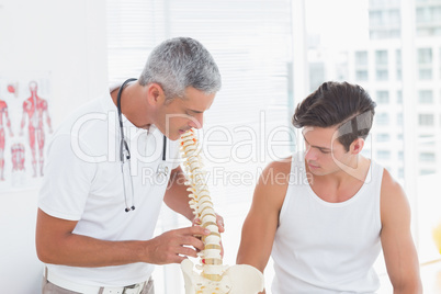 Doctor showing anatomical spine to his patient