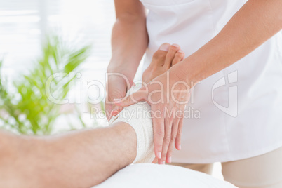 Doctor examining her patient ankle