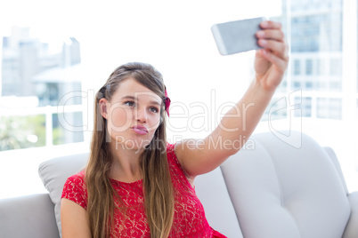 Pretty hipster taking selfie with smartphone