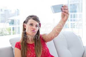 Pretty hipster taking selfie with smartphone