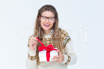 Happy geeky hipster smiling at camera and holding present