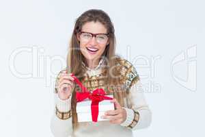 Happy geeky hipster smiling at camera and holding present