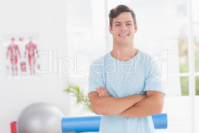 Young man smiling at camera with arms crossed