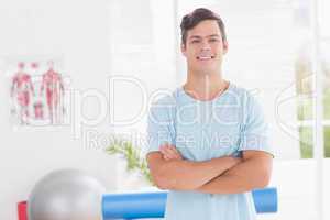 Young man smiling at camera with arms crossed