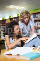 Student getting help from classmate in library