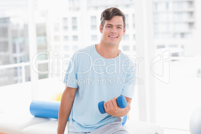 Young man training with dumbbell