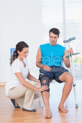 Doctor examining her patient knee