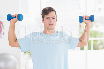 Young man training with dumbbells