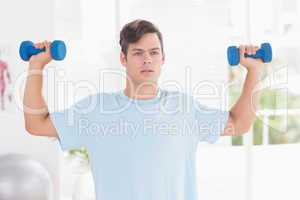 Young man training with dumbbells